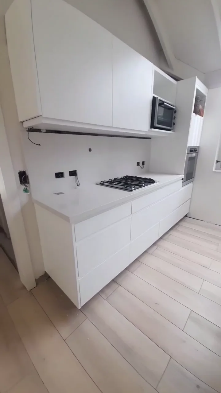 Cocina blanco laqueado con piso símil madera