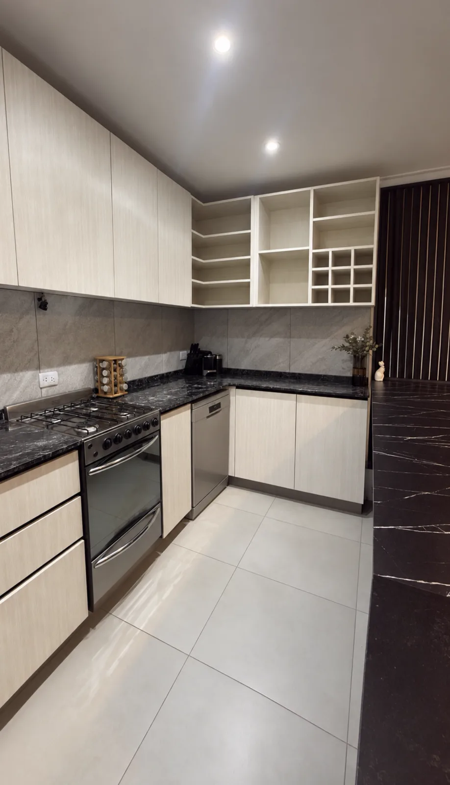 Cocina en tonos claros con isla oscura, vista lateral