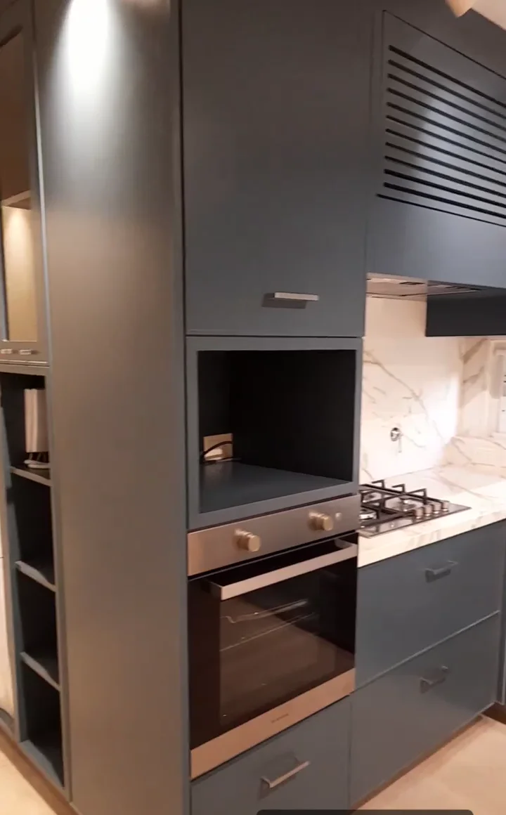 Cocina en gris oscuro con columna de horno y heladera