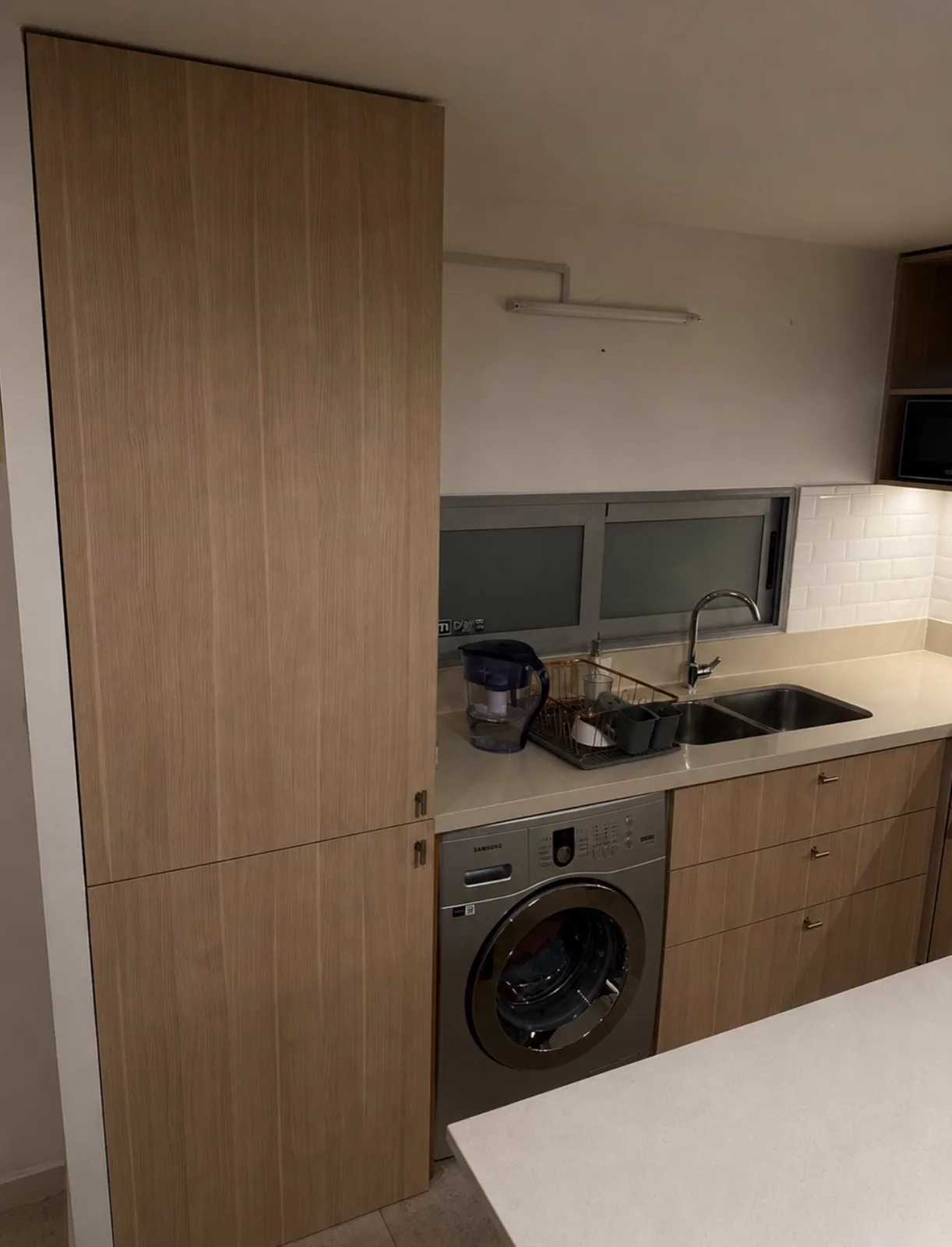 Cocina en texturados madera con columna alta y lavarropas