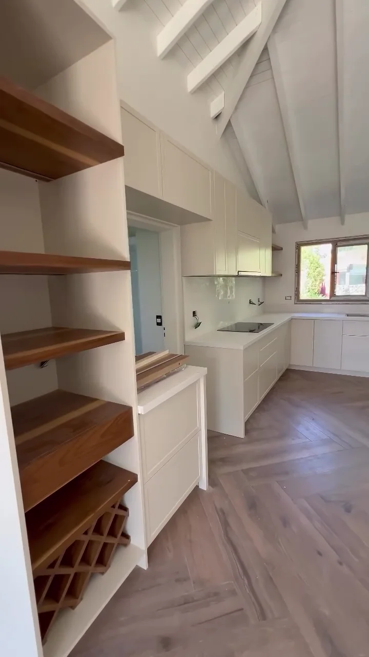 Estantes de madera con porta botellas junto a una cocina